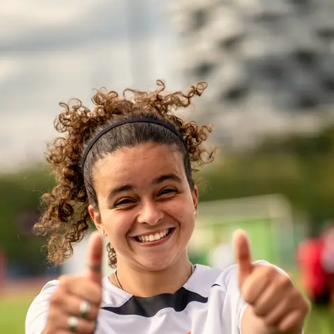 A smiling player giving two thumbs up.